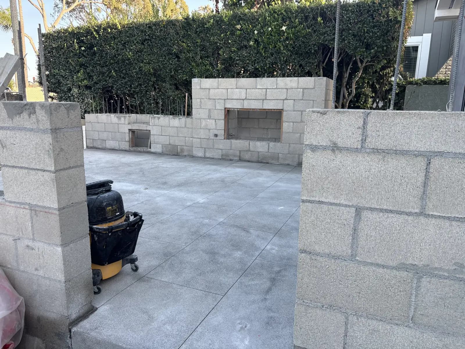 A finished block wall and concrete slab with a recessed planter opening left in the wall